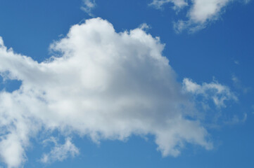 Obraz premium Bright White Clouds Covering Half of Blue Sky – Natural Atmospheric Background for Design Templates, Sky Textures, or Calming Concepts