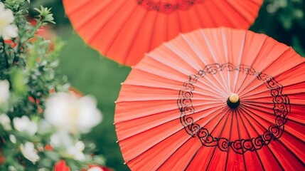 Red Japanese paper umbrellas in a garden setting.  Beautiful, vibrant, and detailed close-up.