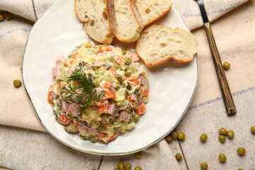 Plate of tasty Olivier salad on table