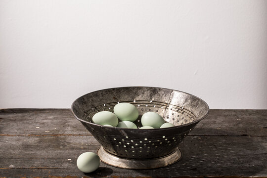 Blue eggs in vintage metal colander