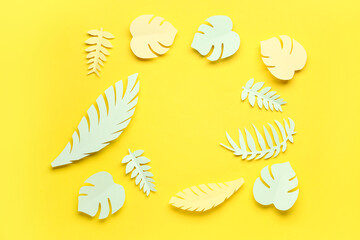Frame made of paper tropical leaves on yellow background
