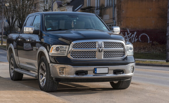Polska Ostrowiec Świętokrzyski 7 lutego 2025 12:58 DODGE RAM 1500  Czarny amerykański terenowy pickup w lutowym słońcu zaparkowany na ulicy Światło słoneczne odbija się od chromowanej osłony chłodnicy