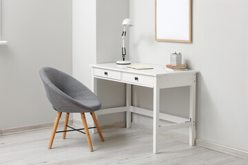 Interior of light room with workplace and armchair