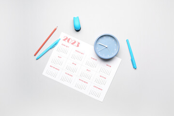 Calendar, pencils and clock on grey background