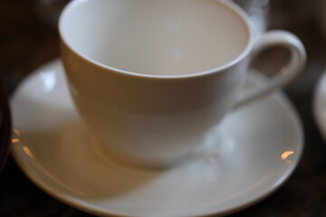 A white cup and saucer placed on a table, perfect for a cozy morning or afternoon tea.