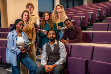 University students posing in lecture hall with notebooks