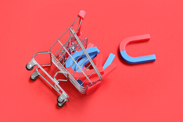 Mini trolley with magnets on red background