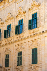 Obraz premium View of old building with windows, balconies in city. Republic of Malta, the picturesque city of Valetta, Malta.