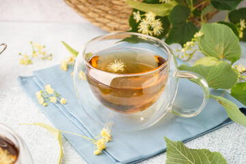 Glass cup of linden tea on white background