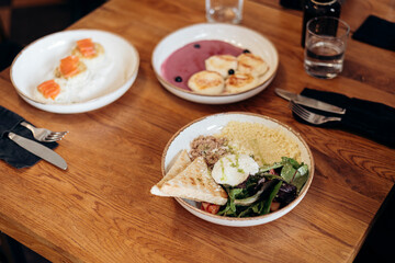 Breakfast bowl with couscous, poached egg, tuna and greens, healthy nutrition.
