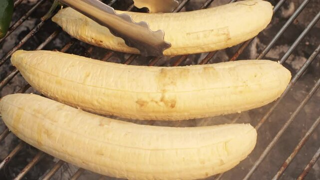 Grilled Banana on fire, latin american vegan grill with avocado and pepper, thai or Ecuadorian Street food. African traditional food on grill. 