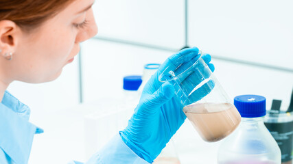 Woman in a scientific ecology laboratory. Examining a water sample.