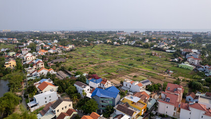 Aerial view of suburban landscape with houses and farmland, rural development, serene community living, Vietnam
