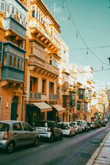 Obraz premium Typical narrow streets with colorful balconies in VallettaTypical narrow streets with colorful balconies. Narrow streets with colourful window boxes in Valetta, MaltaTraditional Maltese balconies in V