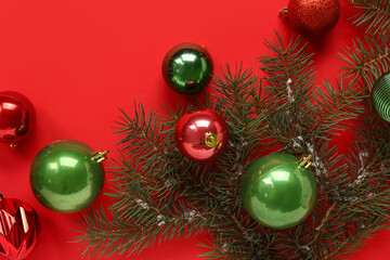 Fir twigs with Christmas balls on red background