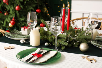 Stylish table setting with Christmas wreath and burning candles, closeup