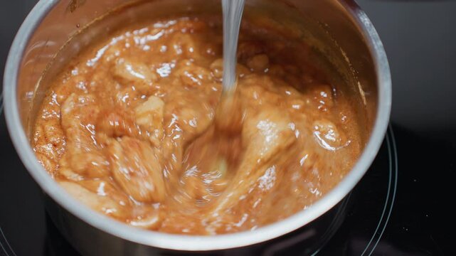 Close-up of person stirring thick, creamy pap in a pot on an electric stove, the texture changes as it is mixed, the steam rises, showing the heat of the cooking