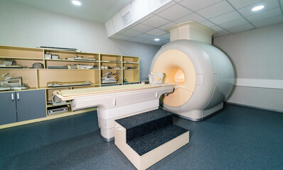 MRI in exam room. A modern MRI machine is located in a well-organized medical examination room,...