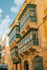 Typical narrow streets with colorful balconies in VallettaTypical narrow streets with colorful balconies. Narrow streets with colourful window boxes in Valetta, Malta Traditional Maltese balconies