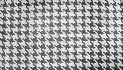 close-up shot of a black and white houndstooth pattern on a woven fabric, showcasing the classic textile design suitable for fashion and interior applications, repeating  pattern background.
