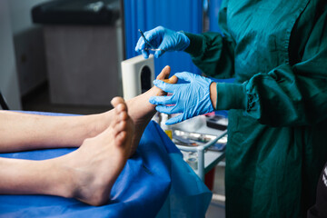 A podiatric surgeon treating a patient in a hospital