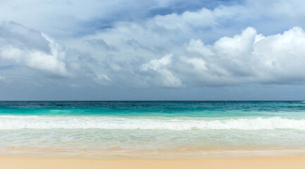 A serene tropical beach featuring soft sandy shores, turquoise waves