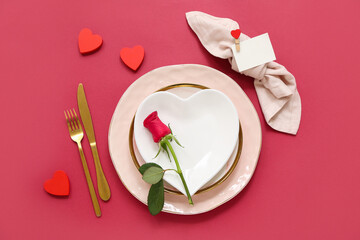 Beautiful table setting with red rose and hearts on color background. Valentine's Day celebration