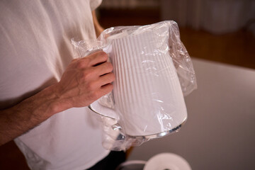 Unboxing a stylish, modern kettle designed for use in a bright, contemporary kitchen space