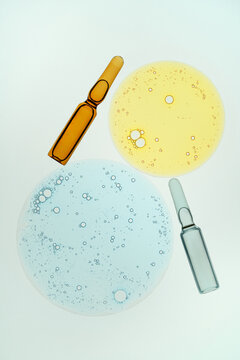 Ampoules and colored liquids in petri dish with bubbles