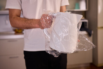 Unboxing a stylish, modern kettle designed for use in a bright, contemporary kitchen space