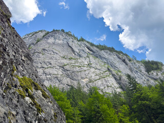 A mountain stands tall under a blue sky with fluffy clouds