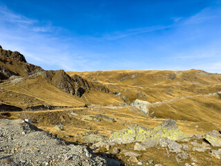 A stunning rocky mountain landscape lit by sunlight under a blue sky