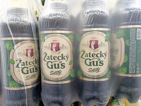 Žateck&yacute; gus beer bottles in plastic packaging displayed on store shelf