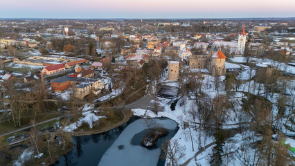 Cesis City, Latvia Aerial View With Medieval St. John’s Church and Ruins of the Beautiful Castle a Residence of the Livonian Order in the Middle Ages. Winter Evening Landscape at Sunset. City in snow