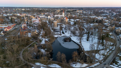 Cesis City, Latvia Aerial View With Medieval St. John’s Church and Ruins of the Beautiful Castle a Residence of the Livonian Order in the Middle Ages. Winter Evening Landscape at Sunset. City in snow