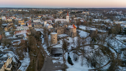 Cesis City, Latvia Aerial View With Medieval St. John’s Church and Ruins of the Beautiful Castle a Residence of the Livonian Order in the Middle Ages. Winter Evening Landscape at Sunset. City in snow