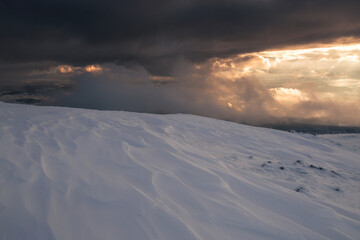 Babia Góra at sunset, covered in winter snow. A stunning mountain landscape in Babia Góra National Park, Poland. Golden light contrasts with icy peaks, creating a breathtaking view for nature and trav
