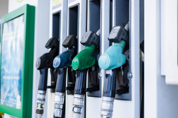 Fuel pumps at a gas station during daylight hours in a busy urban area © Alina