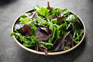Fresh salad leaves mix salad juicy healthy snack micro greens, arugula, lettuce, oak leaf, green leaf salad tasty food background on the table rustic food top view copy space vegetarian and vegan