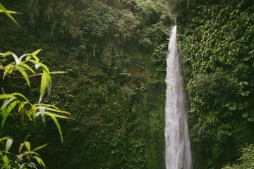 A stunning waterfall in La Cascada village, Chile, surrounded by lush greenery and rugged rocks....