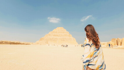 Tourist walking towards the step pyramid of djoser in saqqara, egypt