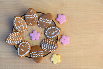 Plate with Easter gingerbread cookies in a shape of egg and flowers, copy space for text