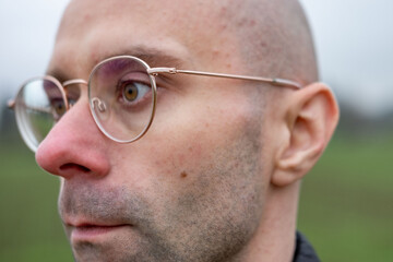 Obraz premium Man in glasses looking away, reflecting. Eyewear style, human eyesight, and introspective moment, contemporary style, intellectual look, male portrait