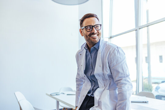 Smiling Businessman in Office Setting Wearing Glasses and White Coat