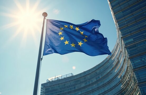 EU flag waving wind against modern parliament building on sunny day. European Union emblem flutters freedom, unity. Symbol of international collaboration, economic partnership against blue sky
