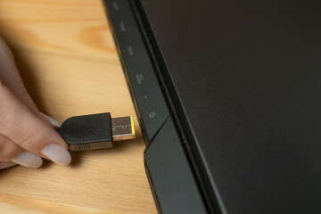 The process of plugging a charger into a laptop in a home office environment is demonstrated,...