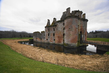 13 Century Caerlaverock Castle built with red sandstone and has a moat surrounded by earthwork...