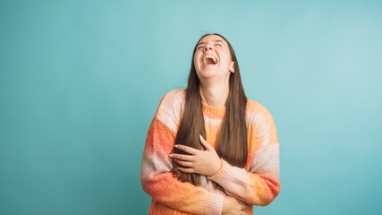 Obraz premium Joyful woman laughing against blue background