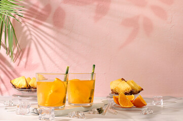 Cocktail with tequila, rum and vodka with pineapple slices, orange, ice and rosemary. Summer party concept. Diet drink for body detox and weight loss, advertising for a bar or cafe,