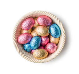 Chocolate easter eggs wrapped in multi colored foil in bowl isolated on white background.